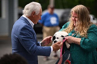 Mayor Terry Hartwick (left) meets with Butterball, one of the shelter's puppies, and Wendy Gregan, treasurer for the North Little Rock Friends of Animals, during the groundbreaking event Wednesday for the NLR Animal Shelter renovation and expansion. (Arkansas Democrat-Gazette/Staci Vandagriff)